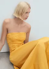 Vestido midi de color amarillo con cuerpo tipo corset fruncido y falda evasé de corte amplio. Presenta un diseño sin tirantes y está confeccionado en una mezcla de algodón con textura.