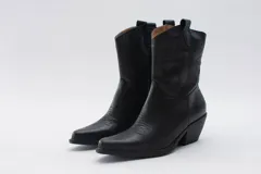 Botas de estilo western (texanas) de caña media, color blanco, confeccionadas en cuero. Presentan bordados decorativos en la caña y puntera cuadrada. Cuentan con cierre lateral y taco de altura media.