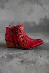 Bota corta de cuero rojo con diseño pintado a mano, inserciones laterales de cuero nonato dorado y negro, taco cuadrado de madera y doble cierre lateral con tiradores metálicos personalizados.