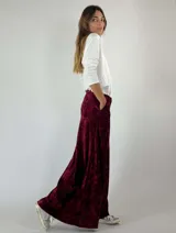 Pantalón palazzo de terciopelo color borgoña con textura arrugada y bolsillos laterales.