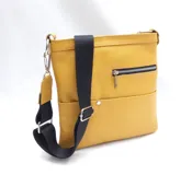 Morral tipo bandolera de cuero texturizado color mostaza, con correa ancha de tela negra ajustable. Presenta un bolsillo exterior con cierre metálico y un bolsillo frontal abierto.