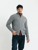 Cardigan de punto gris con cuello alto, cierre frontal de metal con doble cursor y bolsillos laterales. Presenta puños y cuello en tejido canalé.