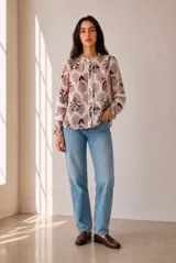 Camisa de manga larga con estampado floral en tonos azules y blancos, cuello con volados y detalles de encaje a lo largo de la botonadura y en las mangas.