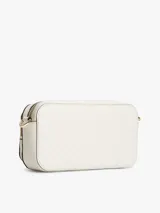 Cartera tipo cámara Tommy Hilfiger color beige, con acabado texturizado, monograma TH en bajo relieve y herrajes dorados. Cuenta con correa cruzada ajustable y extraíble, cierre de cremallera y un bolsillo exterior.