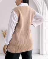 Chaleco largo de punto color beige, con cuello redondo y bolsillos frontales. Diseño sin mangas y corte recto.