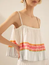 Top corto blanco plisado, con breteles finos y estampado multicolor en el pecho.