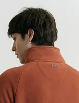Sweater de micropolar color rojo, con cuello alto y cierre frontal parcial. Cuenta con mangas largas y bolsillos laterales con cierre.