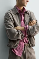 Cazadora de algodón de corte relajado, color marrón grisáceo con efecto lavado. Presenta cuello solapa con tachas metálicas, cierre frontal de cremallera, bolsillos de plastrón en la cadera y puños y bajo elásticos.