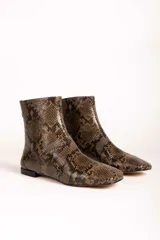 Bota corta de cuero con textura de piel de serpiente en tonos marrones y negros, con punta cuadrada y taco bajo.