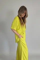 Conjunto color lima compuesto por un remerón de lino de corte holgado con cuello en V y un pantalón palazzo con cintura elástica.