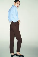 Jeans de tiro alto con corte mom fit, cinco bolsillos y cierre frontal con cremallera y botón.
