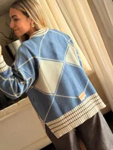 Saco tejido de algodón con lurex, diseño de rombos en color azul y beige, con cuello redondo, cierre frontal de botones y mangas abullonadas.