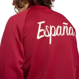 Campera deportiva Adidas de la selección de España, color bordó con cierre frontal, cuello alto y las icónicas tres tiras blancas en las mangas. Presenta el logo de Adidas Originals en el pecho derecho y el escudo de la selección en el pecho izquierdo.