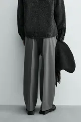 Pantalón de corte wide fit confeccionado en tejido fluido con viscosa. Presenta bolsillos delanteros, bolsillos traseros de vivo, cierre frontal con cremallera y botón, y trabillas para cinturón.