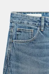 Jeans de tiro medio con corte baggy barrel, cinco bolsillos y costuras laterales curvas. Cierre frontal con cremallera y botón metálico.