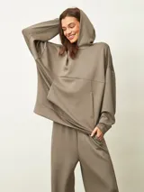 Buzo azul oscuro con capucha, corte oversize, manga larga y bolsillo canguro frontal.