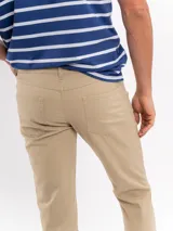 Pantalon tipo chino de corte recto, color beige, con cierre frontal y bolsillos laterales.