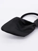 Colero de pelo negro con moño de cuero sintético.