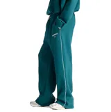 Pantalón deportivo New Balance de corte holgado, confeccionado en felpa cepillada color verde. Presenta cintura elástica con cordón ajustable, bolsillos laterales y logo de la marca estampado en la pierna izquierda.