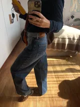 Jean de corte recto y largo, de tiro medio, color gris oscuro con efecto lavado. Presenta un bordado de estrella en los bolsillos traseros.
