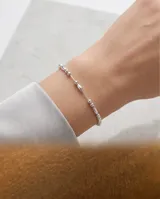 Pulsera de plata fina con abalorios de cuentas esféricas y cilíndricas intercaladas a lo largo de la cadena.