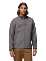Chaqueta Columbia Ascender Soft Shell color gris, resistente al viento y la lluvia, con cierre frontal, bolsillos con cremallera en el pecho y laterales, y cuello alto.
