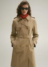 Trench coat de corte recto y diseño cruzado, confeccionado en algodón con acabado repelente al agua. Presenta cuello de solapa, cierre frontal con botones efecto carey, cinturón ajustable en la cintura, trabillas en los puños y abertura posterior en el bajo.
