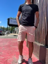 Bermuda cargo de gabardina en color azul marino, con bolsillos laterales con solapa y detalle de etiqueta de cuero sintético.