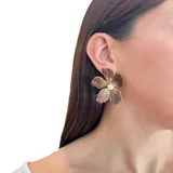 Aros dorados con forma de flor, pétalos esmaltados en marrón y centro con perla.