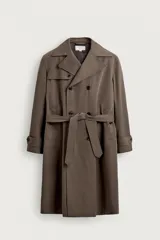 Trench coat de corte regular fit en color marrón, confeccionado en tejido técnico repelente al agua de origen italiano por Manteco. Presenta diseño de botonadura cruzada, solapas de muesca, bolsillos de vivo en la cadera, mangas largas con puños ajustables mediante trabillas y cintura ajustable con un cinturón del mismo tejido.