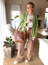 Blazer de lino verde, liviano, con solapas clásicas, bolsillos con solapa y cierre frontal de un botón.