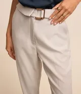 Pantalón negro de vestir, de corte recto, con tiro alto, cinturón con hebilla metálica y bolsillos laterales.