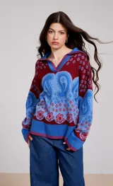 Sweater de punto con cuello polo, diseño de estampado paisley y flores en tonos azul y bordó, de corte holgado y manga larga.