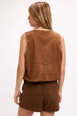 Chaleco de gamuza sintética color marrón, con costuras artesanales en contraste a lo largo de los bordes frontales y diseño sin mangas.