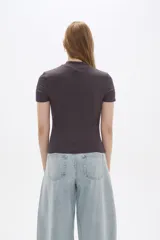 Remera de manga corta, color gris oscuro, confeccionada en tejido acanalado (punto canale) de viscosa, de corte ajustado al cuerpo y cuello alto tipo mock neck.