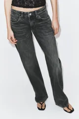 Jeans de tiro bajo con diseño wide leg y corte full length. Presenta cinco bolsillos, cierre frontal con cremallera y botón metálico, en un lavado de denim claro.