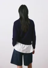 Jersey de punto canalé color azul marino, con cuello redondo y diseño de manga larga.