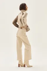 Jean de tiro alto y pierna ancha, color beige claro, con terminación deshilachada en el ruedo.