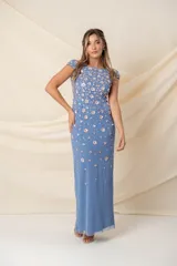 Vestido largo de tul color celeste con aplicaciones de lentejuelas formando flores, de corte recto y tajo trasero.