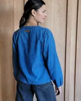 Blusa celeste de manga larga con escote en V y detalle bordado en el cuello.