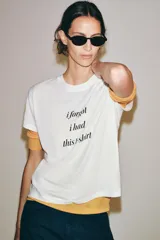 Camiseta blanca de manga corta y cuello redondo, con estampado frontal de texto en color negro que dice "i forgot i had this t-shirt".