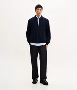Campera estilo bomber de color negro, confeccionada con tejido repelente al agua. Posee cuello semi alto, cierre frontal con cremallera, bolsillos laterales y puños y dobladillo elastizados. Marca Marfinno.