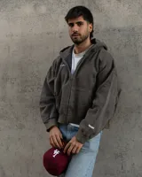 Canguro con capucha color gris oscuro, con cierre frontal y bolsillos tipo canguro.