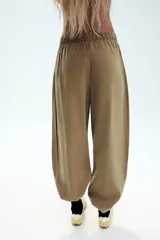 Pantalón fluido confeccionado en mezcla de modal, de tiro medio con cintura elástica ajustable con cordón y bolsillos laterales, en color tostado.
