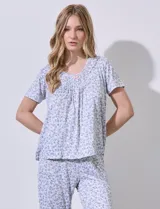 Conjunto de pijama marca René Rofé, compuesto por remera de manga corta con cuello redondo y aplique de puntilla, y pantalón capri con cintura elastizada, ambos en tejido soft estampado con motivos florales.