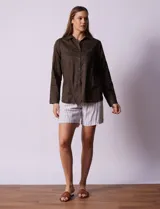 Camisa color verde oliva de lyocell, marca Cyrus. Tiene cuello con solapa, abertura central con botones, mangas 3/4 regulables con presilla y botón, y dos bolsillos delanteros aplicados.