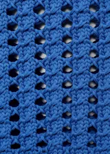 Jersey de manga corta confeccionado en tejido de punto grueso con diseño de crochet. Presenta cuello redondo, corte recto y diseño crop con terminaciones en tejido acanalado.
