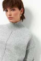 Polera de tejido de punto color bordó, con cuello alto, manga larga y costura vertical central en el frente.