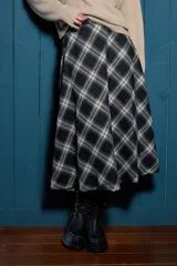 Falda midi de corte evasé con estampado de cuadros en tonos negro, gris y beige. Presenta una caída fluida y diseño atemporal.