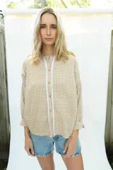 Camisa de manga larga con estampado vichy en color mostaza y blanco, cuello mao y apliques de encaje en la pechera. Diseño holgado con cierre frontal de botones y mangas con puños elásticos.